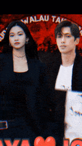 a man and a woman standing in front of a sign that says ' walou tal '