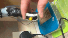 a person is holding a toy car on top of a blue box .