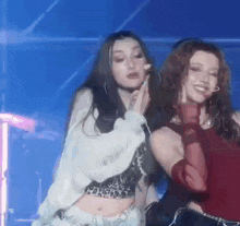 a couple of women are standing next to each other on a stage and dancing .