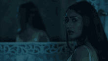 a woman looks at her reflection in the mirror