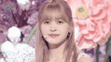 a close up of a woman 's face with flowers in the background and the word mbc on the bottom