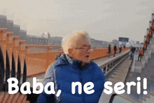 a woman in a blue jacket stands on an escalator with the words baba ne seri written below her