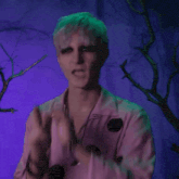 a man wearing a pink shirt with black polka dots is making a funny face