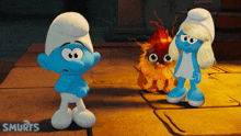a smurf standing next to another smurf and a fireball