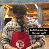 a man wearing an apron with a m on it