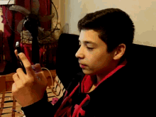 a young boy wearing headphones looks at his phone