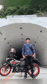 a man standing next to a motorcycle in front of a tunnel that says kaybiang tunnel