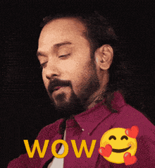 a man with a beard is wearing a red shirt with the word wow written in yellow