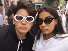 two girls wearing sunglasses are posing for a picture together