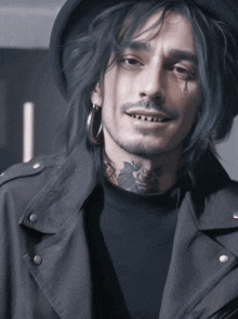 a man with a tattoo on his neck is wearing a hat and a black jacket
