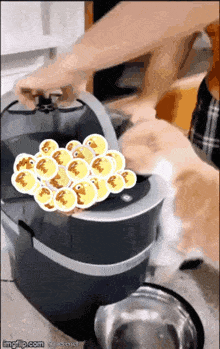 a gif of a person putting a bunch of ducks in a bucket