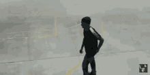 two men are playing basketball in a parking lot and their shadows are visible on the ground