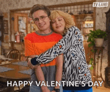 a man and a woman are hugging each other in a living room on valentine 's day .