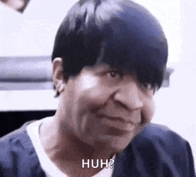 a woman with short black hair is making a funny face .