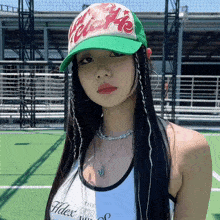 a woman wearing a green hat that says " hello " on it