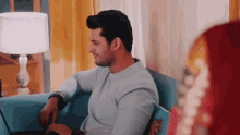 a man is sitting on a couch using a laptop computer .