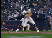 a baseball player in a brewers uniform is swinging at a pitch