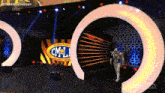 a man in a costume is walking on a stage in front of a sign that says consejo mundial de lucha libre .