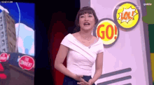 a woman is standing in front of a sign that says go on it