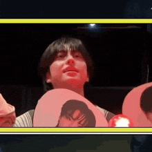 a man is holding a fan with a picture of a man on it in a dark room .