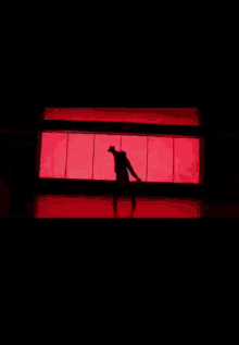 a man is standing in front of a red wall .