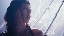 a woman wearing a headband and a necklace looks to the side