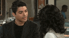 a man and a woman are sitting next to each other in a restaurant .