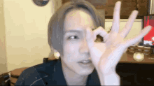 a young man making a ok sign with his hand