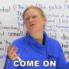 a woman in front of a white board with the word come on on it