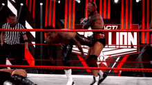 a wrestler is kicking another wrestler in a ring with the word lion on the wall behind them