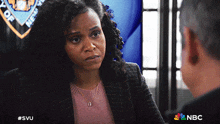 a woman is talking to a man in front of a sign that says department of new york