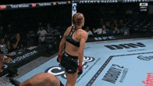 a woman in a boxing ring with jeremy 's razors written on the fence