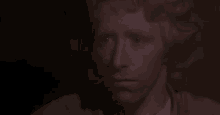 a close up of a man 's face in a dark room in a movie .