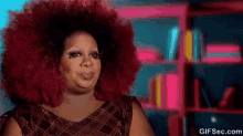 a woman with a large red afro is making a funny face .