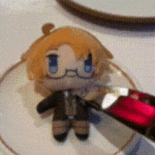 a stuffed doll with glasses and blue eyes is sitting on a cd