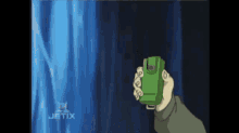 a person is holding a green device in front of a blue curtain with the word jetix on the bottom