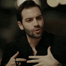 a man with a beard is wearing a ring on his left hand