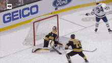 a hockey game is being played in front of a geico banner