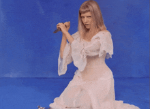 a woman in a white dress is holding a knife in her hand