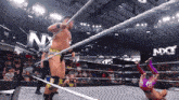 a man in a wrestling ring with nxt written on the ropes