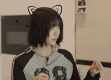 a woman wearing a cat ear headband has the number 98 on her sweater
