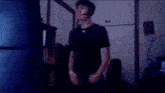 a young man wearing headphones and a black shirt with the letter a on it is standing in a room