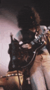 a man with long hair is playing a guitar
