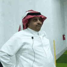 a man in a white shirt with a red and white head scarf around his head