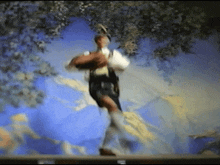 a man is dancing on a stage with a blue background