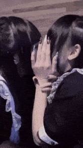 a woman with long nails is covering her face with her hand