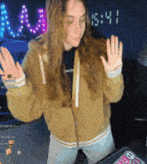 a woman dancing in front of a clock that says 15:44