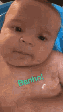 a baby is taking a bath in a bathtub and a person is washing his head .