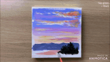 a painting of a sunset is being painted with sap green and black paint