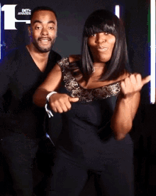 a man and a woman posing for a photo with the bet awards logo in the background